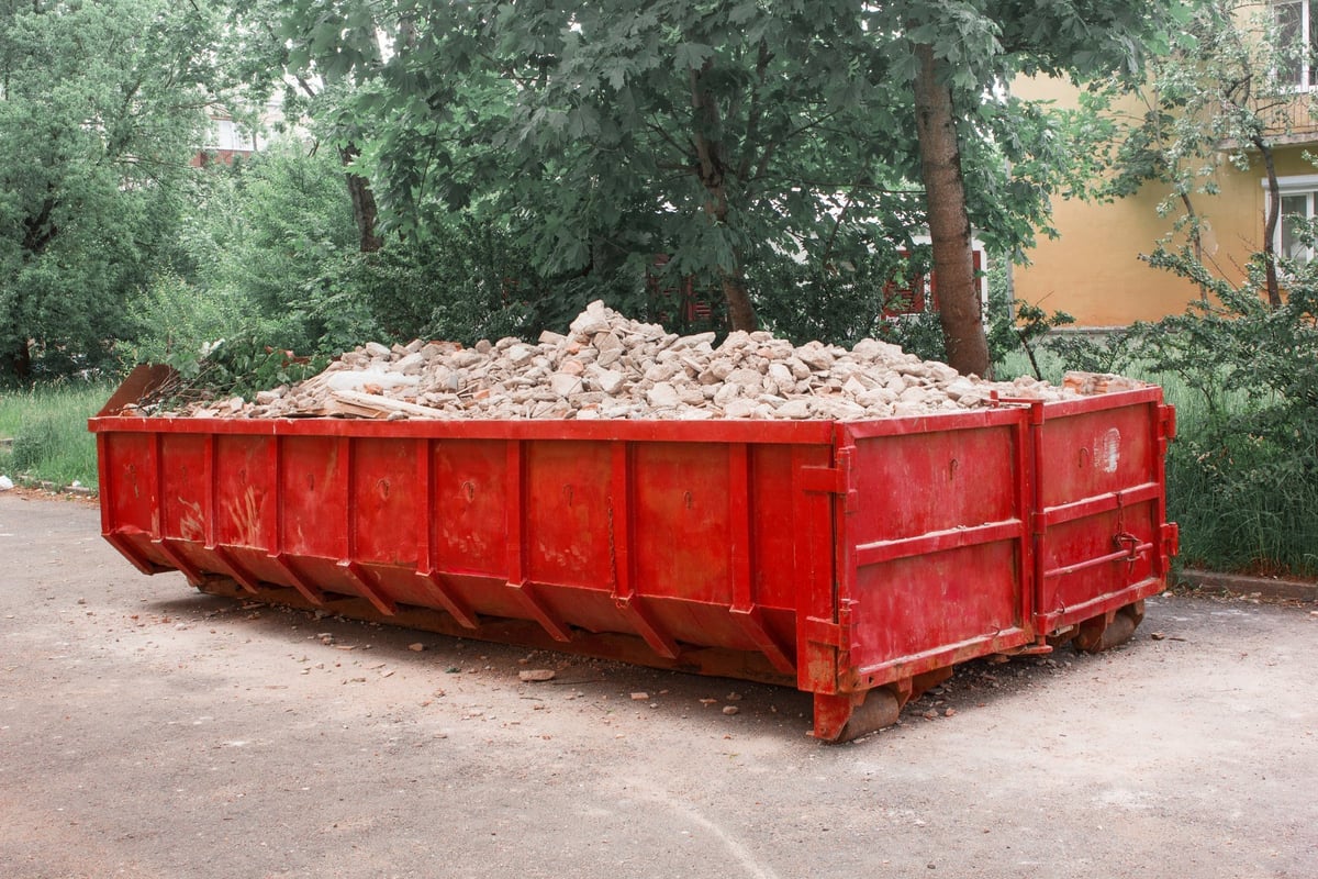 Red dumpster container with construction waste